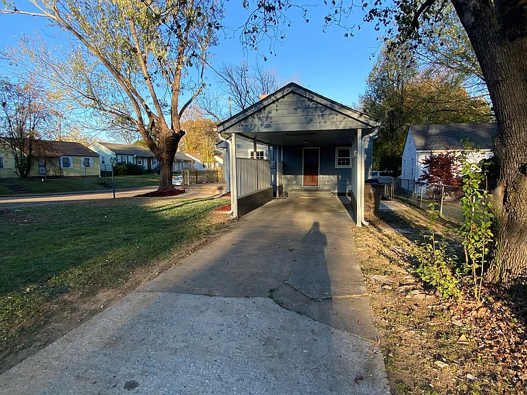 Covered carport with long drive way.
