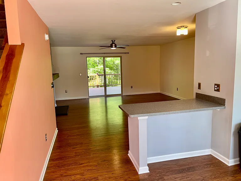View of floorplan from entry. Coat closet and stairs to the left and kitchen on the right. Can fit 4 stools at the peninsula for extra seating.