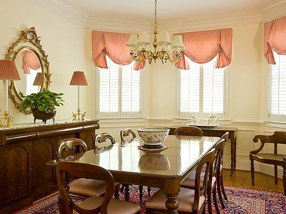 The gracious formal dining room, with wainscoting and plantation shutters, is bright and open.
