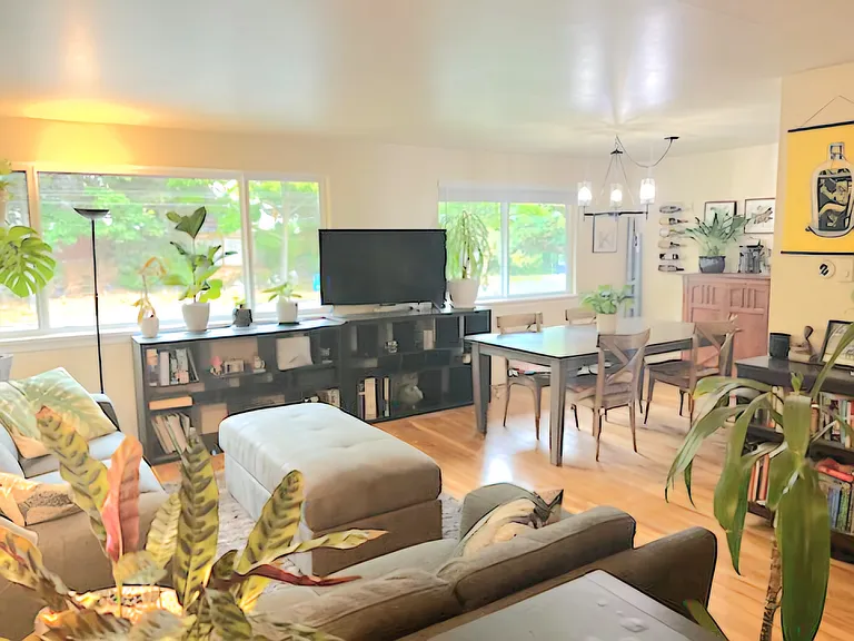 Close up view from front door entry. Spacious open layout on top level for living room, dining table, leads to kitchen on right side by dining table.