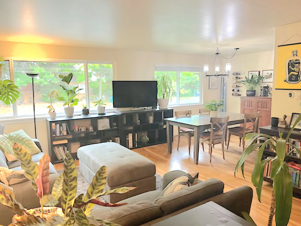 Close up view from front door entry. Spacious open layout on top level for living room, dining table, leads to kitchen on right side by dining table.