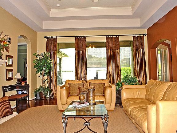 Gorgeous living area with tray ceiling and wood flooring.