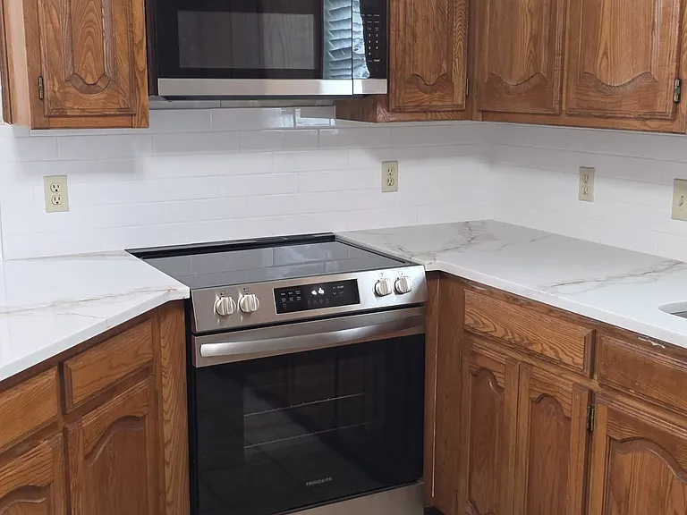 new electric glass surface stove with new microwave, new quartz countertops