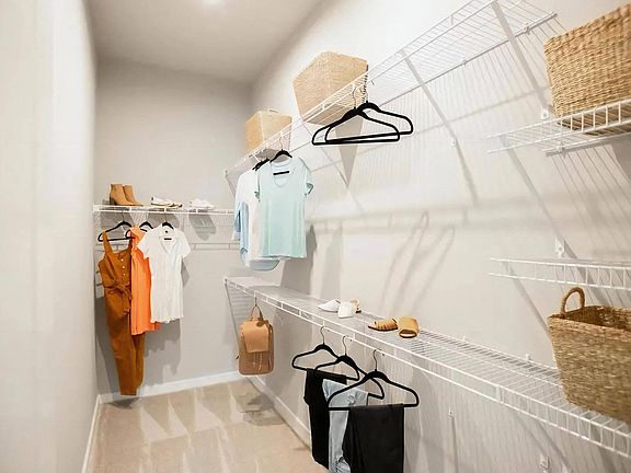 Large Walk-In Closet with Versatile Storage and Natural Carpet Flooring