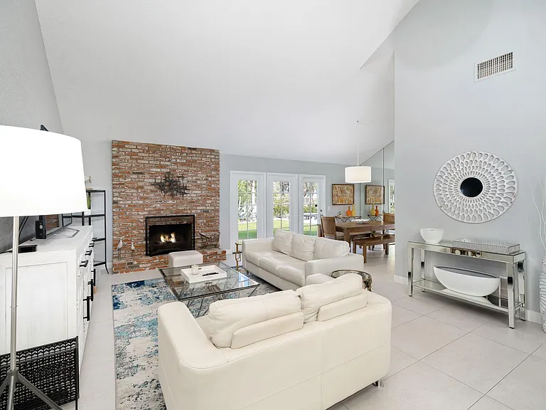 Living room area with dining room in right rear by doors leading outside.