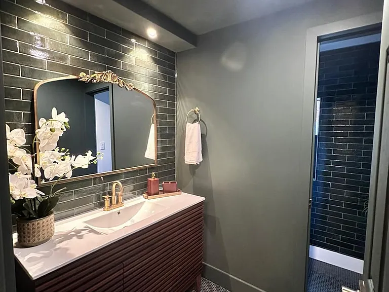 Sophisticated bathroom with gold towel bars, stylish accessories, and ample storage.