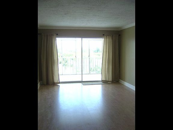 Living Room with side drapes, looks out onto the pool area.