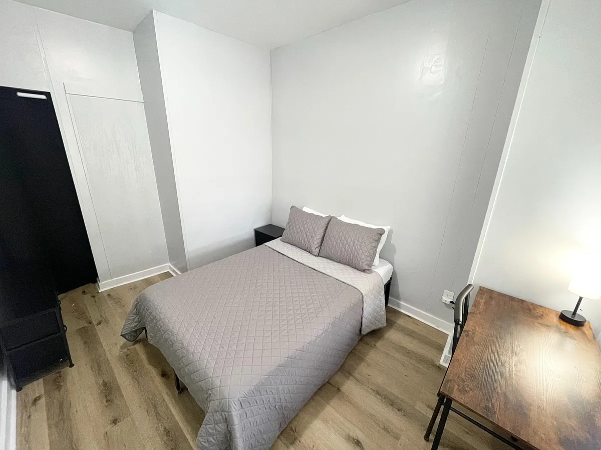 Photo 1 of 6 - N Gladstone Ave - Indianapolis, IN Private bedroom with a full-size bed, nightstand, and desk area, plus wood-look flooring and ample wall space. - N Gladstone Ave