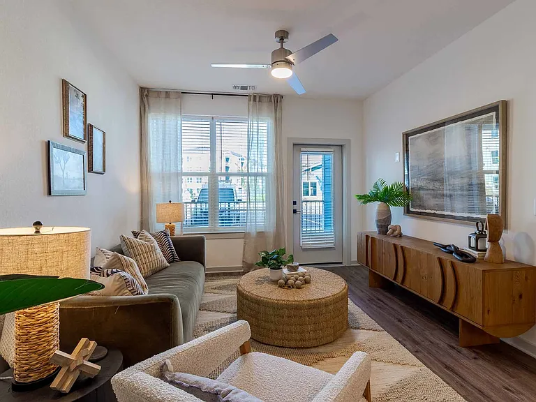 Spacious living area with a ceiling fan and wood-style plank flooring throughout. Spacious living area with a ceiling fan and wood-style plank flooring throughout.