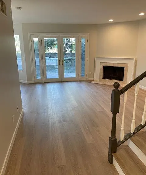 Living room with fireplace and french doors leading to flat backyard