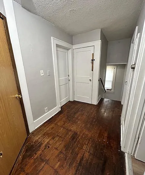 Standing in the central hallway at bedroom #1 doorway looking (from left to right) main living area door, bedroom #2, door that leads to bonus space in attic, internal staircase that leads to exit and the basement.