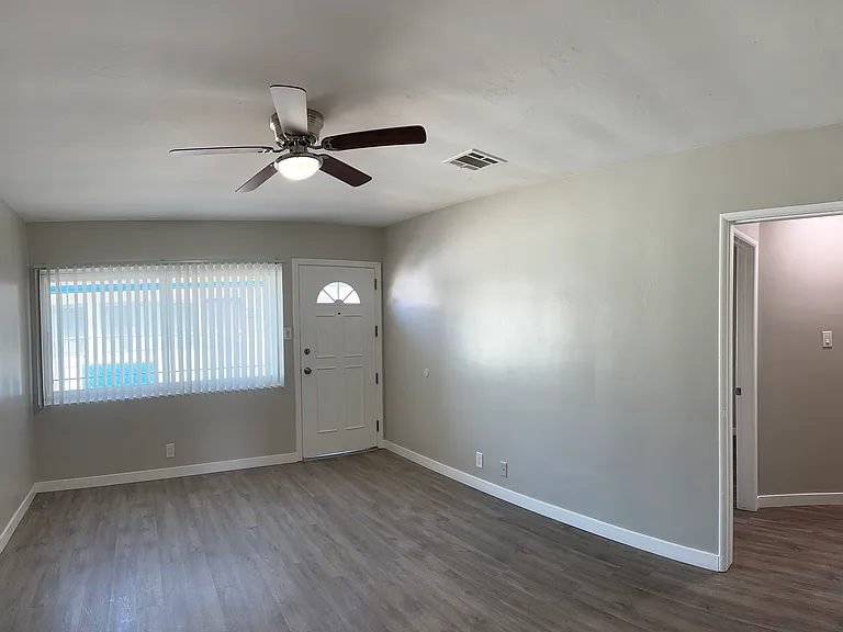 Ample living room spaces with large double pan windows and blinds for privacy