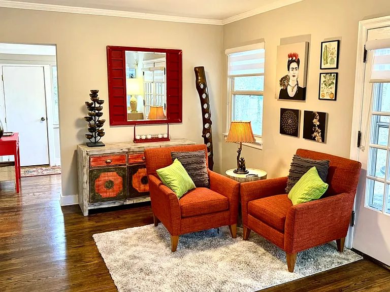 Living room, additional seating with custom arm chairs, one-of-a-kind artist created furniture, artwork, and a wine tree!