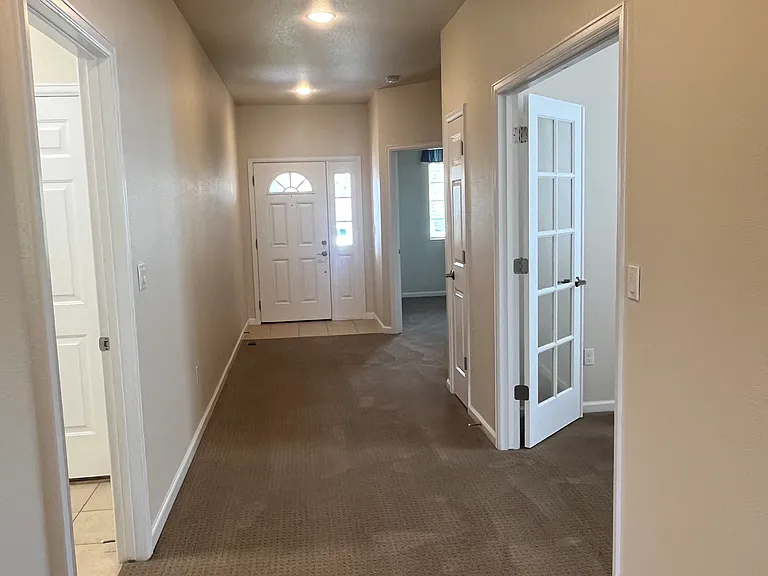 View towards the front door. Additional bedrooms are on the right and laundry / garage are to the left.