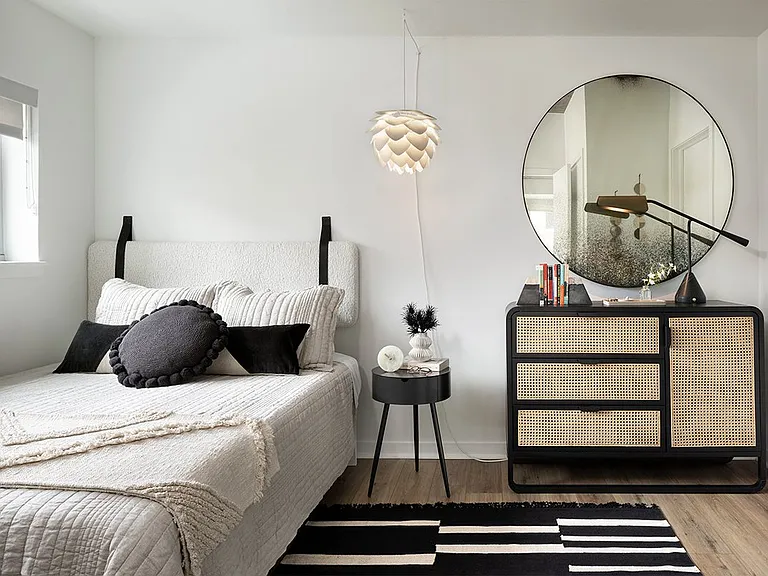 Spacious apartment bedroom with wood-style flooring.