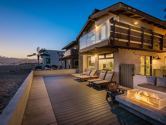 Front deck with firepit and chaise loungers on beach
