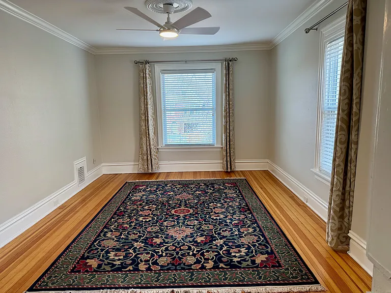 Living room with ceiling fan and original pine flooring