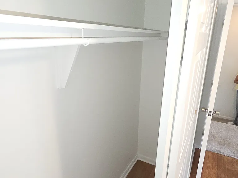 Wide bedroom closet with shelf and hanging storage.
Full bathroom