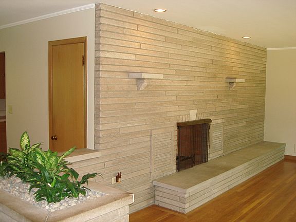 Entry - wood burning fireplace with display shelving and recessed lighting