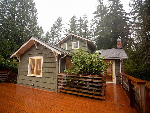 The living room opens on to a spacious back deck accented by heritage rhododendrons.
