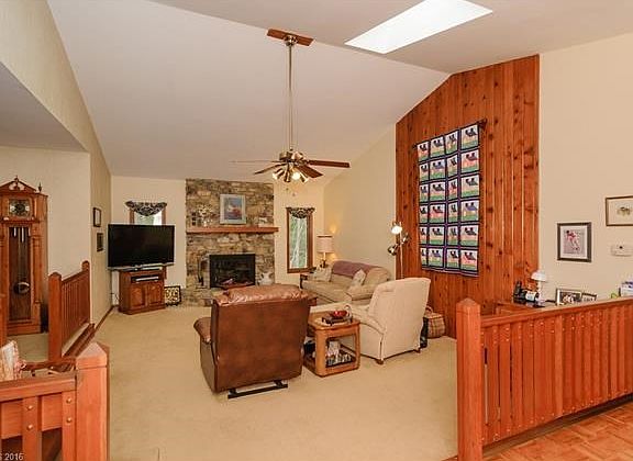 Living Room with a wood burning fireplace and cathedral ceilings