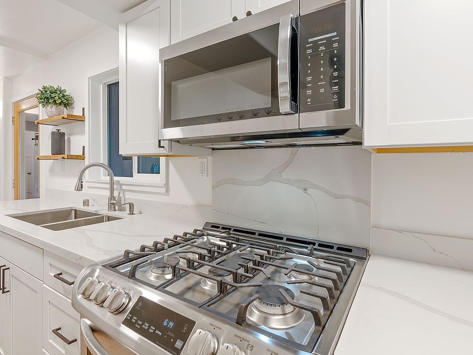 Kitchen - quartz counters, newer cabinets, 5 burner stove, microwave hood, 2 windows and deck access.