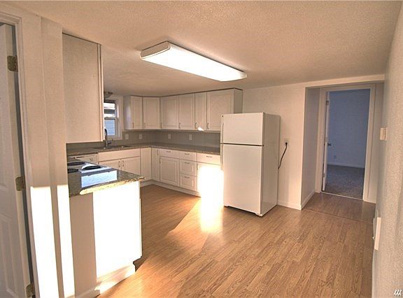 Kitchen with granite counter tops and white cabinets.   Includes stove, fridge, dishwasher and a built in microwave.