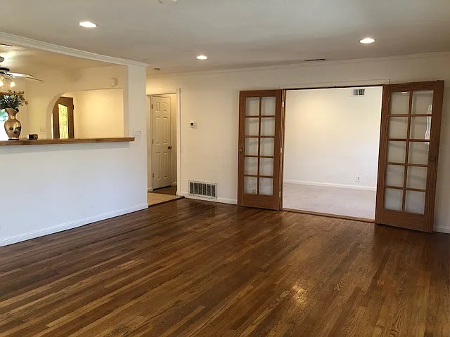 Another living room view. Double French door leads to bedroom #4/office/study room. Left bar divider leads to dining area