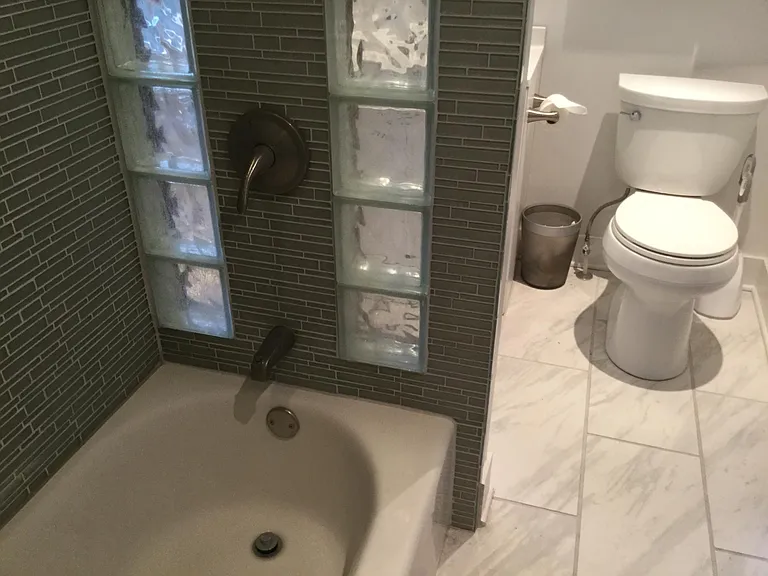 Upstairs bathroom, tub, shower, toilet and sink. Natural light.