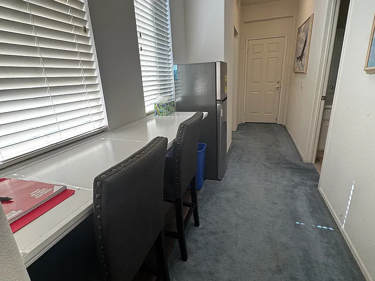 North wing hallway with table top, seating, refrigerator, guest ledger