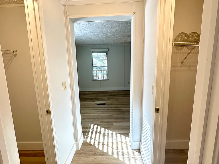Looking from the primary bathroom into the bedroom with the closets in between