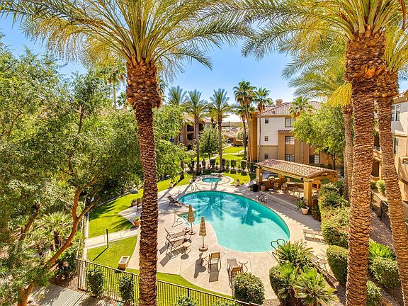 Resort-style outdoor courtyard with a swimming pool, spa, lounge seating, and shaded patio for relaxing or gathering.