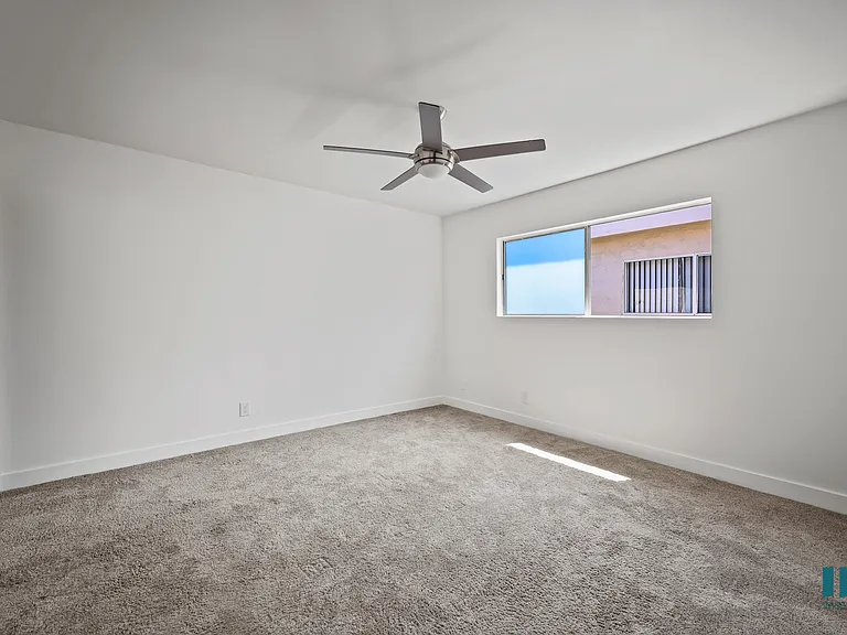 Bedroom with Mirrored Closet, Ceiling Fan, and Carpet