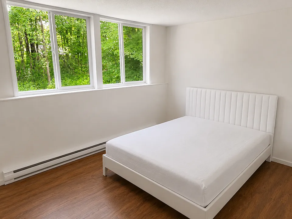 Larger of the 2 bedrooms with 2 large windows overlooking the back yard