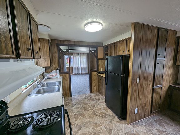Kitchen with new fridge and range. Dishwasher, double sink. To the right of this photo is seen the breakfast nook area.