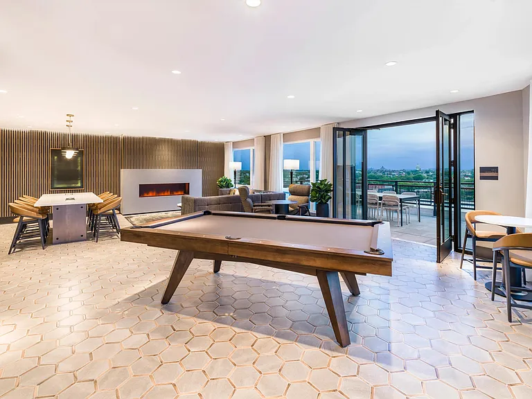 Play, host, or unwind in the rooftop lounge_featuring a fireplace, pool table, and seamless access to panoramic Capitol views on the terrace.