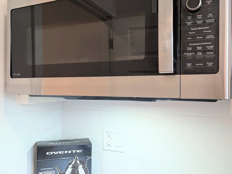 Modern over-the-range microwave paired with a brand-new cooktop provided for tenant use, offering convenient and flexible cooking.