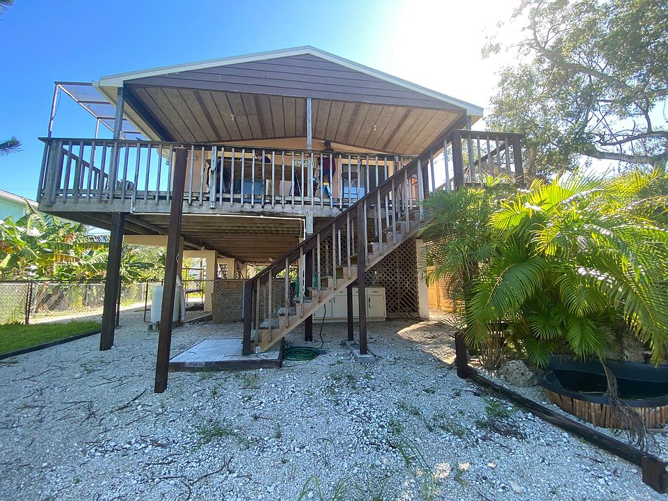 Back of house showing deck overlooking yard and canal