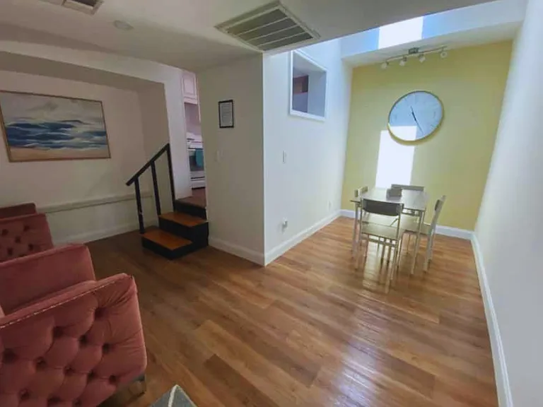 Welcoming living space featuring two armchairs and a dining area for four.