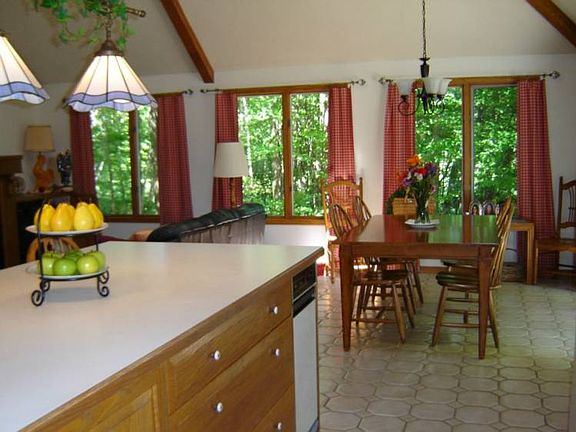 This cozy kitchen with warm sunlite colors has rich oak woodwork and cabinets, a large work island f