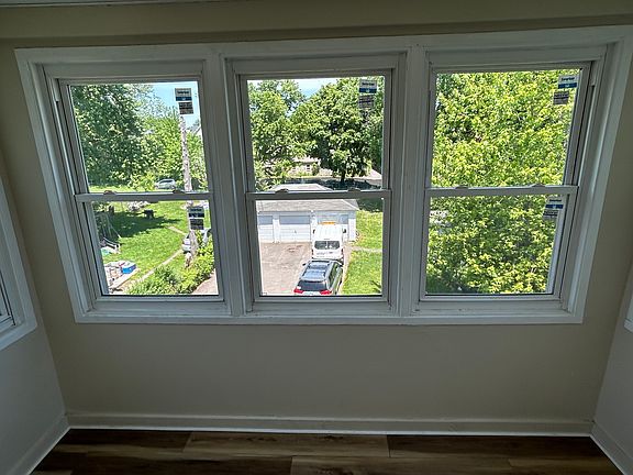 Back porch off kitchen. View of driveway and 3-car garage.