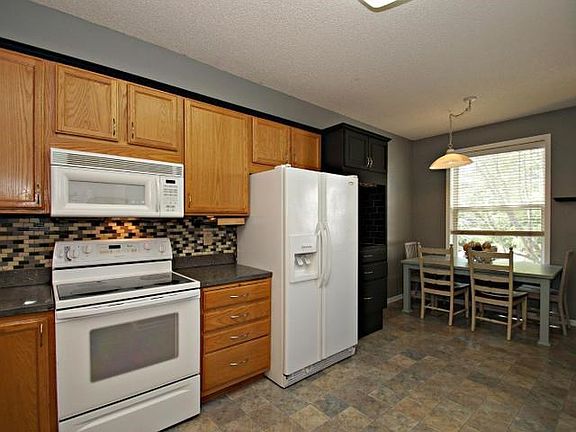 Open and large eat-in kitchen with new flooring, stunning backsplash and neutral pallet.