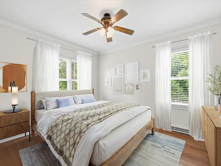 Virtual staging of bedroom 2 with new windows, new window blinds, new interior door, and new doorknob. New trim and fresh paint. Windows face west and south.