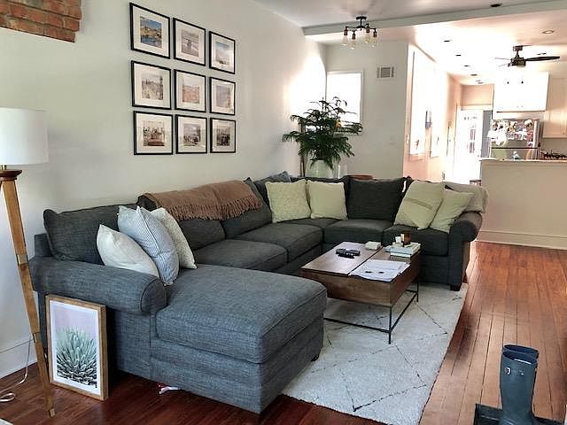 Living room view, near front door of apartment. Kitchen is directly behind sofa.