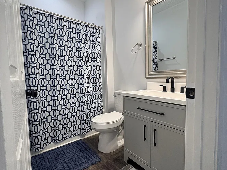 Updated full bathroom with tub/shower combo, single-sink vanity with storage, and durable wood-look flooring.