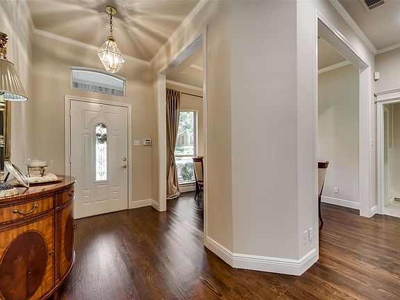 The Entry of this home features beautiful solid wood floors, decor paint colors, crown moldings & high ceilings.