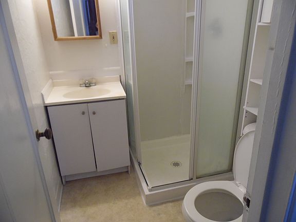 This compact cozy bathroom offers storage for your convenience.