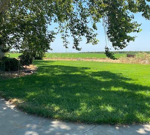 View from back of house. Large patio and lawn area overlooks the fields which are farmed.