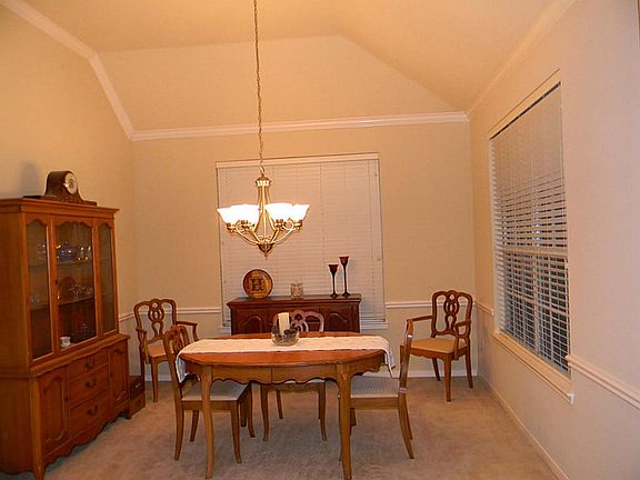 Formal dining offers vaulted ceiling, crown molding and chair-rail molding