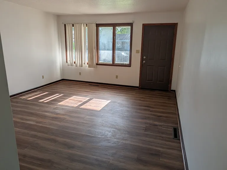 Bright living room with laminate flooring and large window.